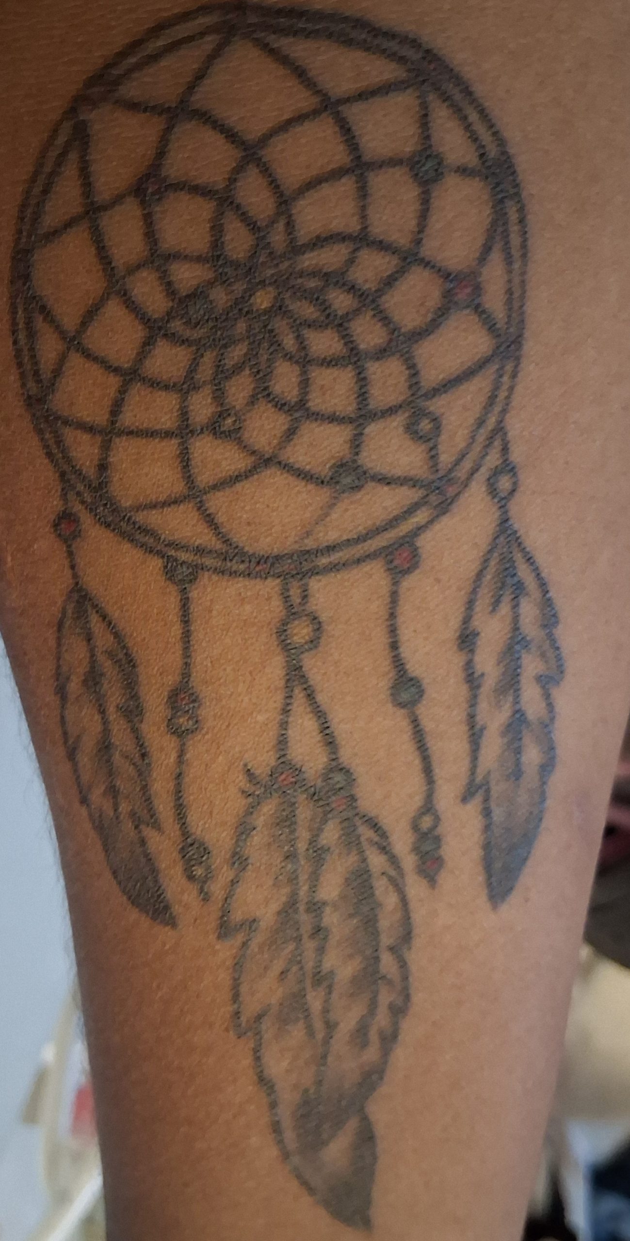 Rising Dreams Foundation Dream Catcher logo in gold, representing youth reaching upward toward their dreams, opportunities, hope, and a brighter future.